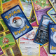 A collection of sleeved Pokémon cards scattered upon my desk, then cropped oh so professionally.